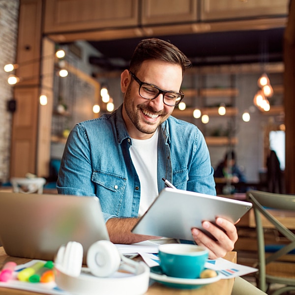 A man at a cafe with a tablet