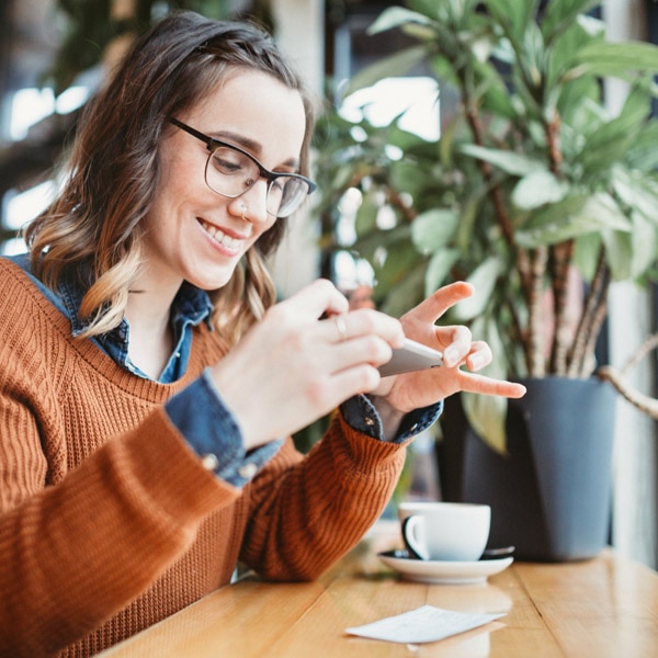 girl taking photo of check with phone