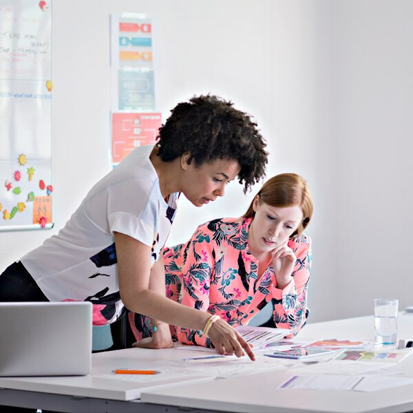 two women reviewing documents on a table