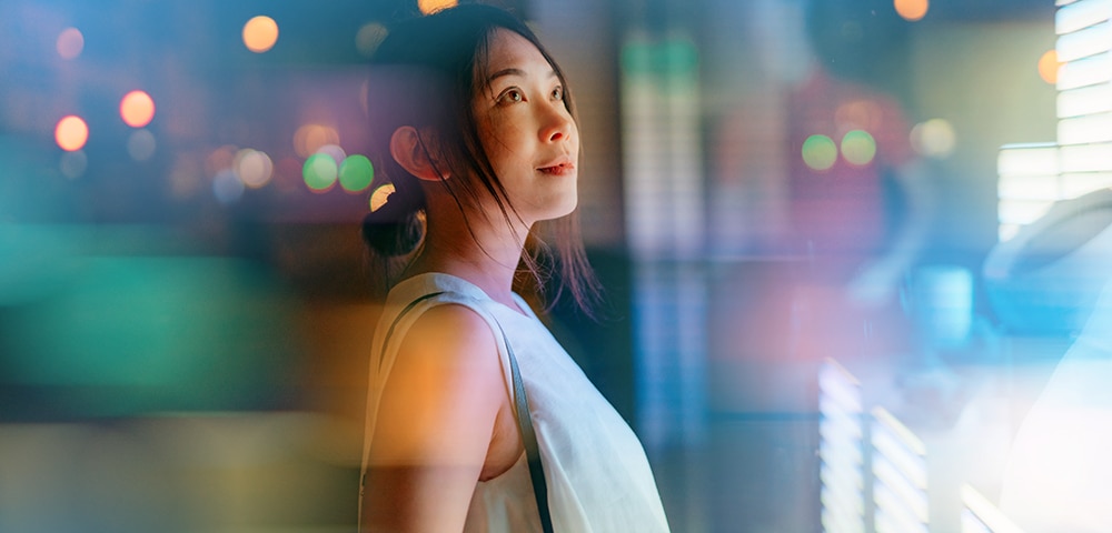 Young Asian businesswoman looking at financial data, standing in front of digital display. Futuristic concepts. Future technology. Cryptocurrency investment.