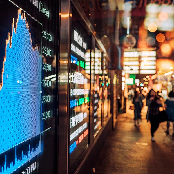 Crowd walking street in front of digital displays